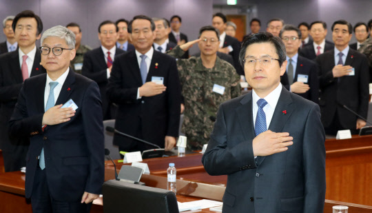 황교안 대통령 권한대행 국무총리 등 참석자들이 4일 정부 서울청사에서 열린 정부 첫 업무보고인 국방부와 외교부, 통일부, 국가보훈처 등 안보관련 부처 업무보고에서 국기에 대한 경례를 하고 있다.